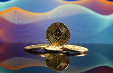 well arranged four pieces of Ethereum gold coins with its reflection below and an artistic background with gradient colors